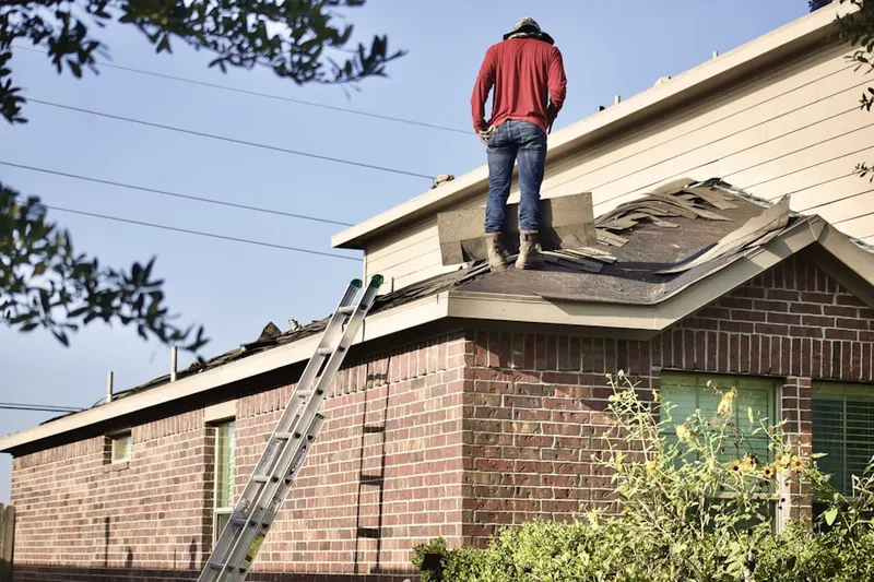 Professional roofer working on a residential roof in Sayville Heights